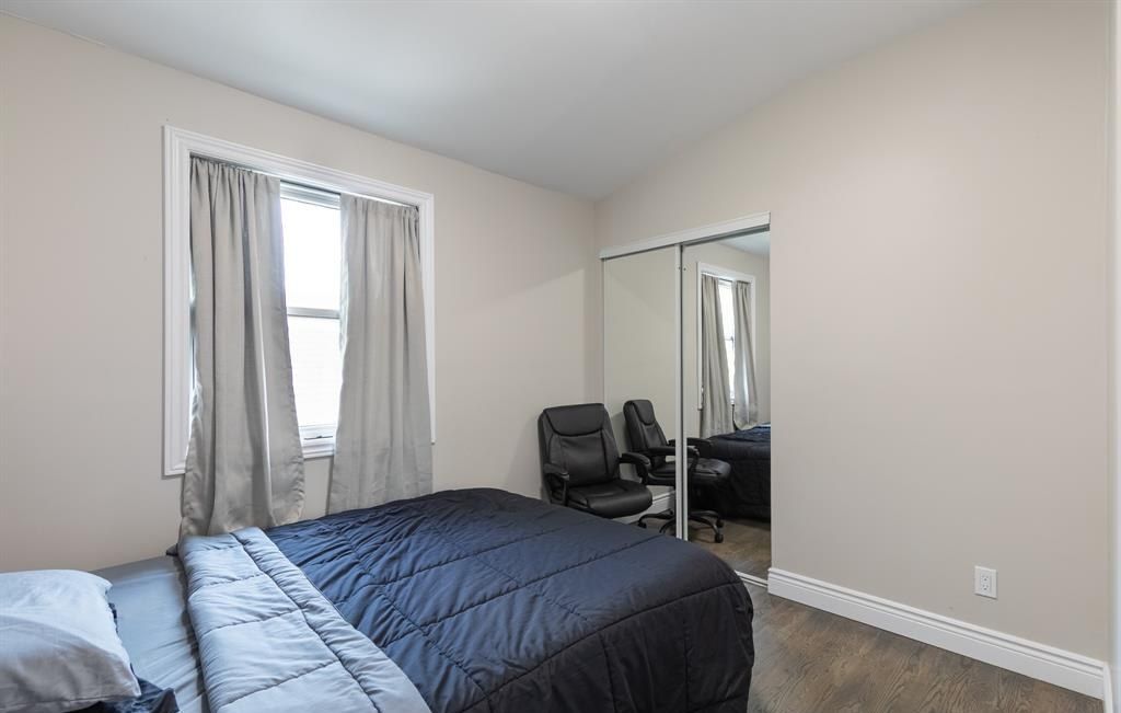 Bedroom with a bed, a mirrored closet and a window.